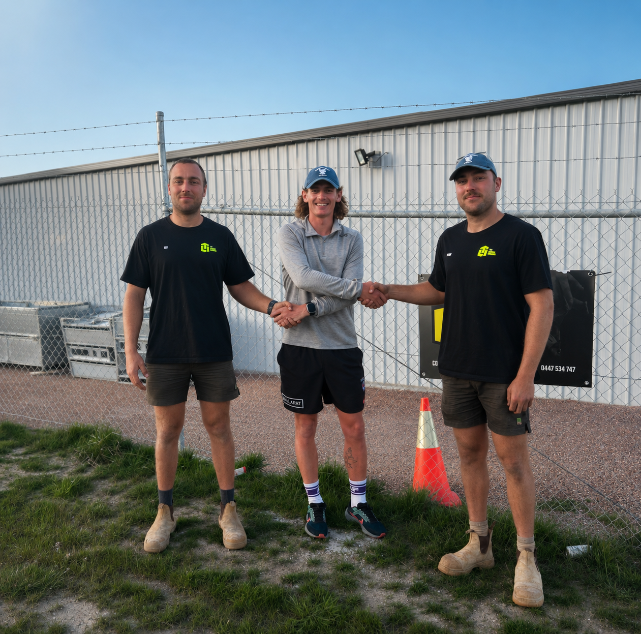 The TLM Concrete Solutions team on site in branded shirts beside their signage