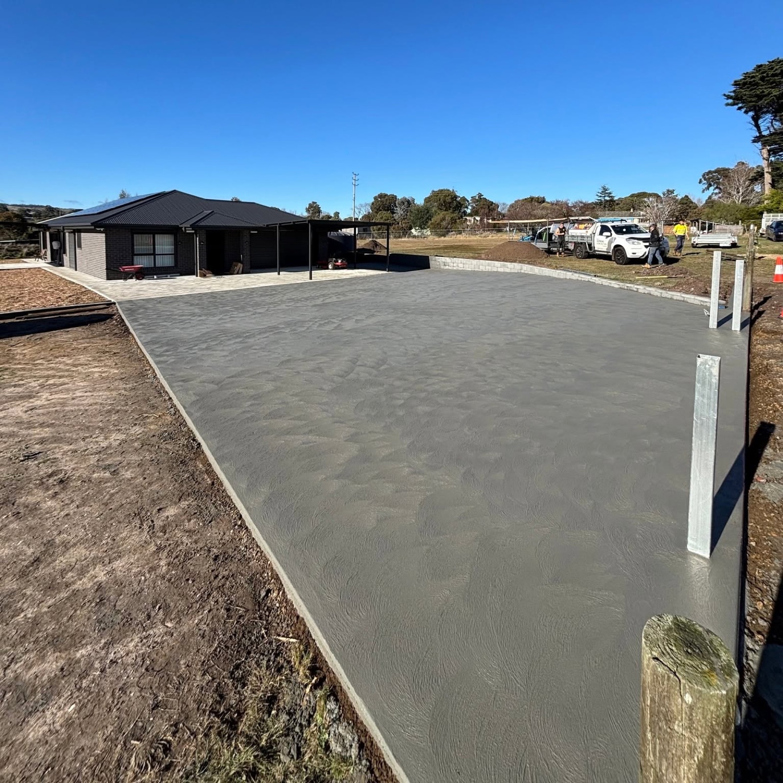 A large broom-finished driveway with the TLM crew on site